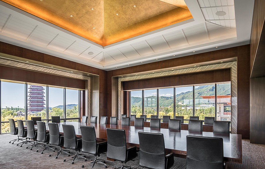 A room with a large group of chairs and large windows.
